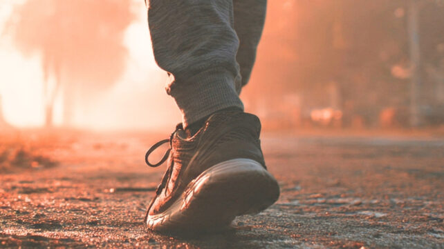 close up of a person's shoe as they walk down a road