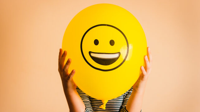 Unrecognizable person holding yellow balloon