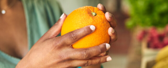 woman holding an orange